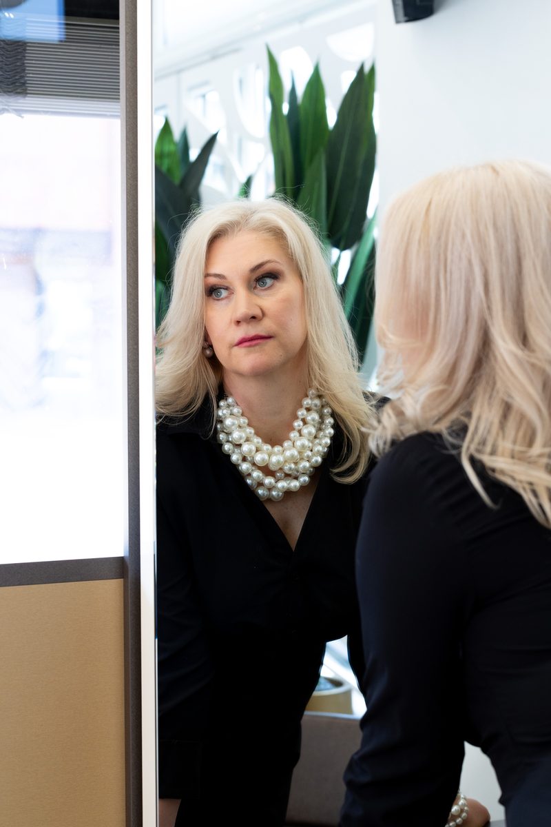 Businessportrait mit Perlenkette vor einem Spiegel