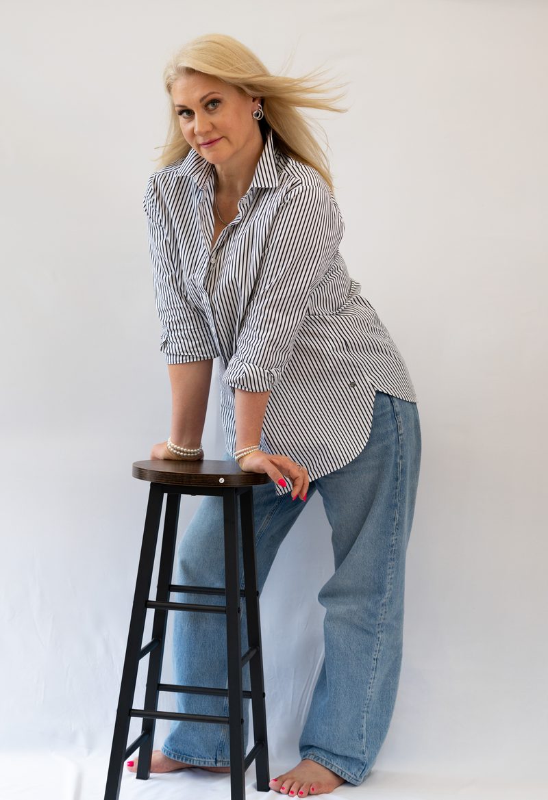 Fashionportrait in Hemd und Jeans an einem Holzhocker