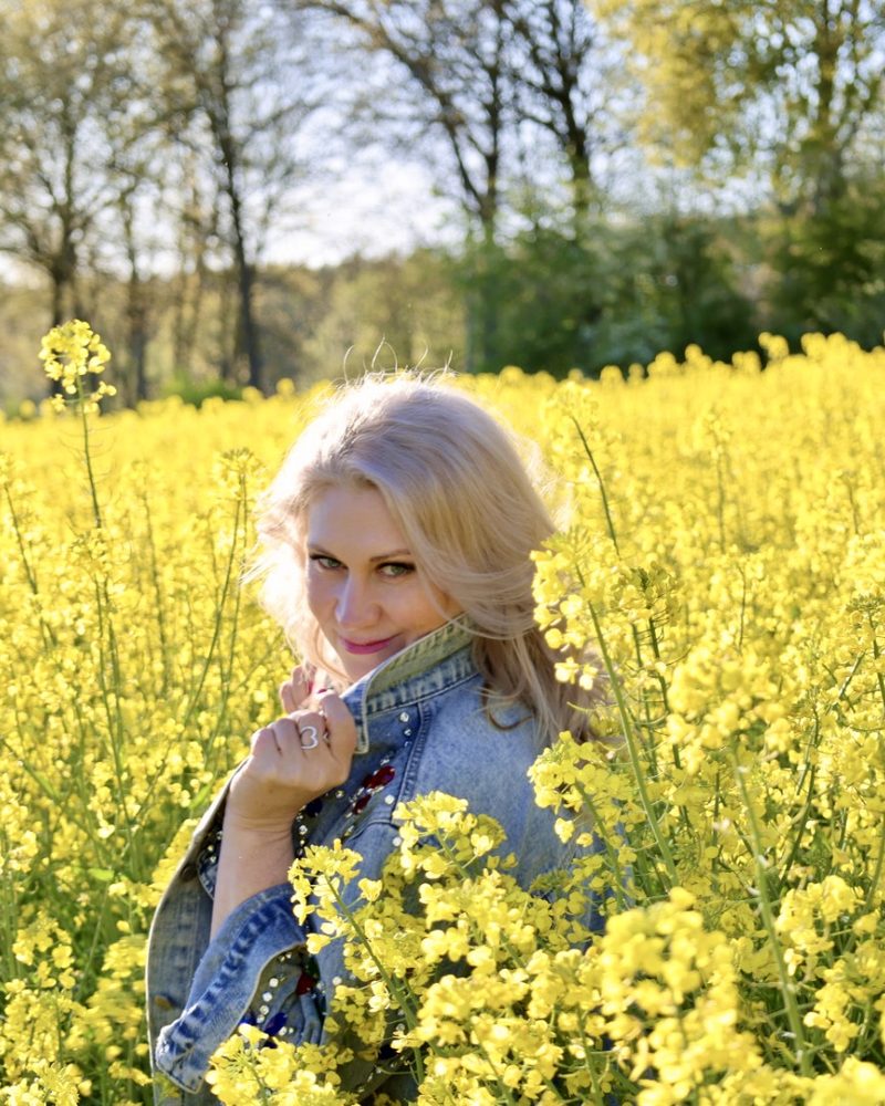 Portrait zwischen gelben Rapsblüten im Frühling